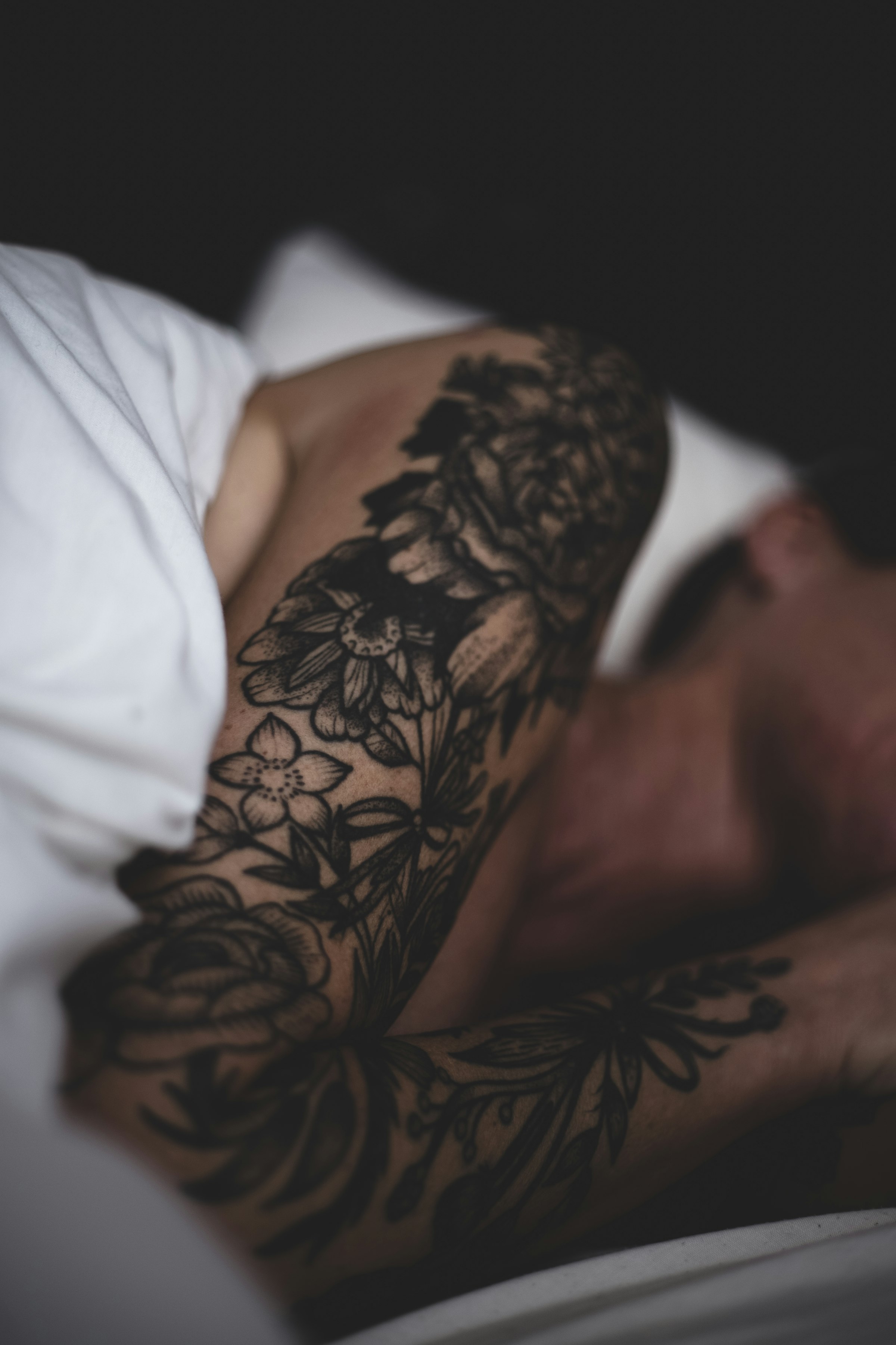Healed black-and-grey floral tattoo work on an arm